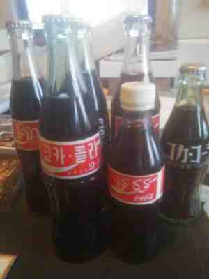 (6) FULL COKE BOTTLES. (2) SAUDIA ARABIA, (1)THIALAND, (2) KOREAN. (1) JAPANESE.