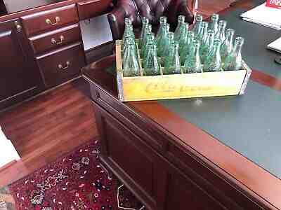 53 each total 6 1/2 ounce Coca Cola bottles in two yellow Coca Cola wooden case.