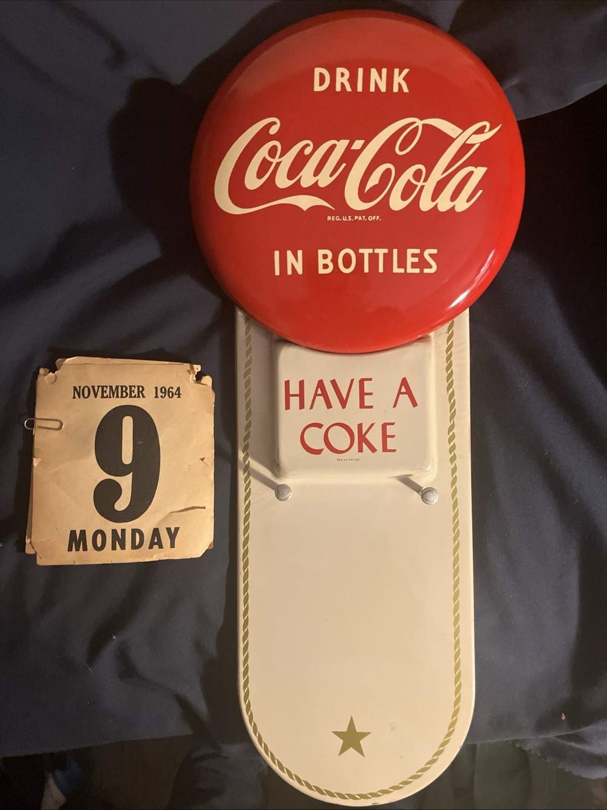 1950’s Coca Cola “drink In Bottles” Calendar Button Sign