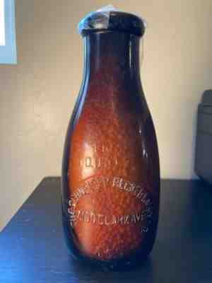 Schneider Becker Dairy vintage quart milk bottle; 7100 Clark Ave, Amber glass