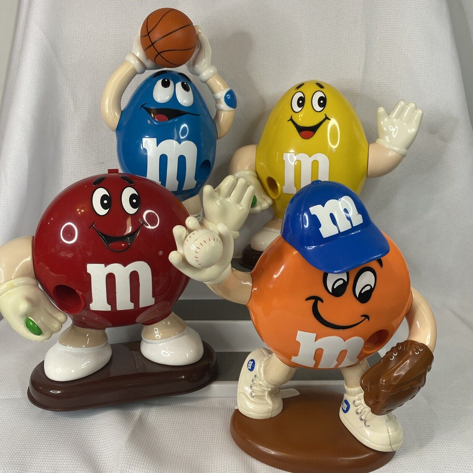 M&M Set of 4 Lg Candy Dispensers (Red, Yellow, Orange Baseball, Blue Basketball)