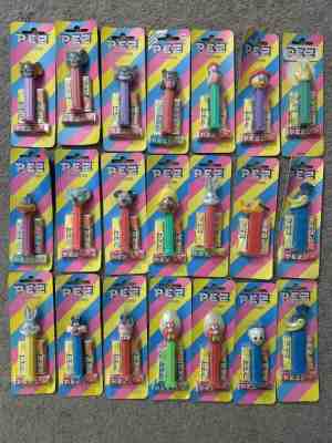 21 PEZ ON OLDER STRIPED CARDS - INCLUDES 2 ROADRUNNERS